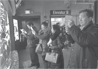  ?? AP PHOTOS ?? Tourists from China take pictures at the New England Aquarium in Boston. In cities across the country, the American hospitalit­y industry is stepping up efforts to make Chinese visitors feel more welcome.