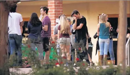  ?? Al Seib Los Angeles Times ?? STUDENTS AND FAMILIES gather at Holy Trinity Lutheran Church in Thousand Oaks on Tuesday to remember Bernard Moon, a Thousand Oaks High student. Many wrote goodbye messages to Moon. “Your friendship made everybody’s lives better,” one read.