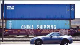  ?? J BROWN/AFP ?? A motorist drives past shipping containers in Long Beach, California.