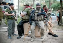  ?? PHOTO: REUTERS ?? Members of the John Brown Gun Club sit with their weapons outside Donald Trump’s rally in Phoenix, Arizona.