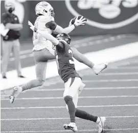  ?? ADAM HUNGER AP ?? Dolphins wide receiver DeVante Parker makes a catch over New York Jets cornerback Bryce Hall on Sunday. Parker finished with eight catches for 119 yards.