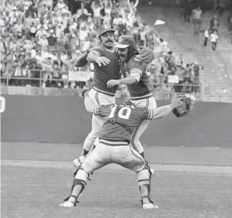  ?? Associated Press 1973 ?? Third baseman Sal Bando (left), catcher Ray Fosse (10) and pitcher Darold Knowles celebrate after the A’s beat the New York Mets to win the World Series in 1973 in Oakland.