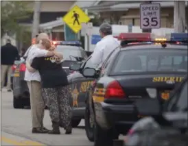 ?? TOM DODGE — THE COLUMBUS DISPATCH VIA AP ?? People hug as emergency personnel arrive to the scene of a shooting outside Pine Kirk nursing home in Kirkersvil­le, Ohio.