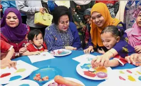  ??  ?? Loving heart: Rosmah (in blue) joining in the activities with some of the students at the newly-opened National Permata Children Centre in Langkawi.