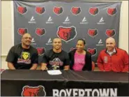  ?? PHOTO COURTESY BOYERTOWN ATHLETICS ?? Boyertown’s Darryl Carver signed his national letter of intent to continue his academic and football careers at King’s College. He is flanked by his parents, Darryl and Gwen Carver, along with Boyertown head coach TJ Miller.