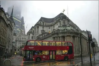  ?? JASON ALDEN / BLOOMBERG ?? A bus passes the Bank of England in the City of London on Feb. 15.