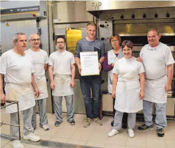  ?? FOTO: MEMU ?? Peter Harscher inmitten seiner Kollegen seines Lehrbetrie­bs, der Bäckerei Mangold in Laichingen.