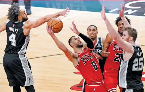  ?? NAM Y. HUH/AP ?? Bulls guard Zach LaVine, who had 29 points, drives to the basket against Spurs guard Derrick White and center Jakob Poeltl in the second half.