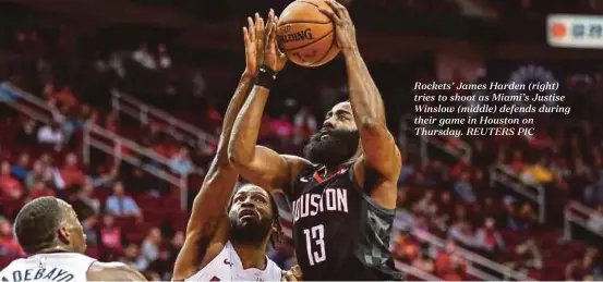  ??  ?? Rockets’ James Harden (right) tries to shoot as Miami’s Justise Winslow (middle) defends during their game in Houston on Thursday. REUTERS PIC