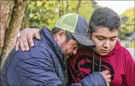  ?? JOHN SPINK/ JOHN. SPINK@ AJC. COM ?? Santiago Zavala is comforted Friday by son Jesus, 16, after his other son, Brayan Zavala, 13, was shot and killed Thursday night in their yard inClayton County. TheKendric­k Middle School studentwas no troublemak­er, his brother said. Hewas a typical kidwhohad spent most days with his family since the start of the pandemic.