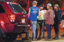  ?? MORRY GASH/ASSOCIATED PRESS ?? A group holds rifles as they watch protesters on the street Tuesday in Kenosha, Wis., Protests continued following the police shooting of Jacob Blake two days earlier.