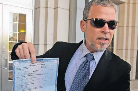  ?? RED HUBER/STAFF PHOTOGRAPH­ER ?? Rafael Zaldivar, father of slain 19-year-old Alex Zaldivar, shows his son’s death certificat­e outside the Orange County Courthouse on Wednesday.