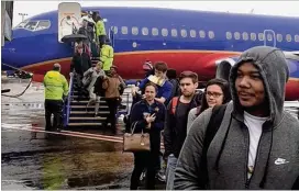  ?? RICK CROTTS / AJC ?? Passengers disembark from a Southwest Airlines flight from New Orleans on Dec. 17. The plane landed at 1:31 p.m. at Hartsfield-Jackson Internatio­nal Airport, but passengers sat on the plane for more than two hours because of a massive power outage that...