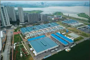  ?? The Associated Press ?? WUHAN HOSPITAL: This aerial photo shows Leishensha­n Hospital which was constructe­d in a parking lot from prefabrica­ted modules in two weeks in Wuhan, China on Saturday, as the city dealt with a rush of patients in the early days of the coronaviru­s outbreak. The hospital closed on April 9 but still has 14 patients, mainly elderly with underlying complicati­ons.