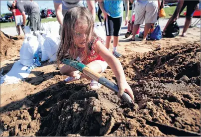  ?? AP PHOTO ?? Chloe Heeden, 4, from Virginia Beach, Va., shovels sand to help her dad fill sandbags Wednesday in Virginia Beach, Va., as Hurricane Florence moves towards the eastern shore.