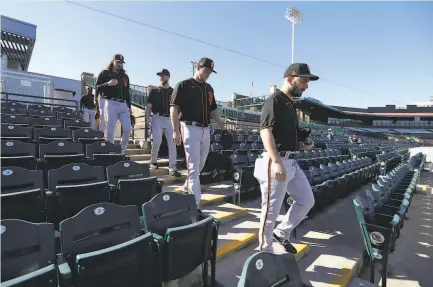  ?? Darron Cummings / Associated Press ?? Top, minorleagu­e lefthander Sam Moll, a nonroster invitee to spring training, leads some Giants to the field for a practice in Scottsdale on Feb. 14.