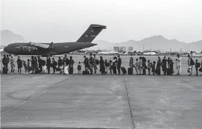  ?? SGT. ISIAH CAMPBELL/U.S. MARINE CORPS ?? Evacuees wait to board a C-17 Monday at Hamid Karzai Internatio­nal Airport in Kabul, Afghanista­n.