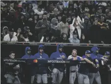  ?? AP PHOTO/ASHLEY ?? Members of the Los Angeles Dodgers look on from the dugout during the ninth inning in Game 4 of a baseball NL Division Series against the San Diego Padres on Saturday in San Diego.