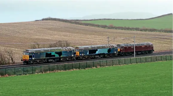  ?? ?? With their DRS logos crudely daubed out, WCR’s Nos. 57011 and 57010 are hauled by No. 47245 south of Oxenholme on March 17 on their way to Carnforth. Rob France