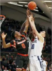  ?? LAURENCE KESTERSON — THE ASSOCIATED PRESS ?? Morgan State guard Stanley Davis, left, a product of Chester High and its affiliate STEM Academy, and Villanova forward Cole Swider reach for a rebound during the second half Tuesday night at the Pavilion.