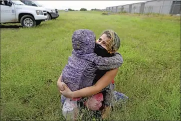  ?? Photograph­s by Gary Coronado Los Angeles Times ?? MILEYDI BARRELA, 26, of Tegucigalp­a, Honduras, and daughter Zoe, 8, who entered the U.S. illegally, wait to board a bus to be processed by Customs and Border Protection in Texas’ Rio Grande Valley last week.