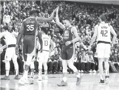  ?? (AP) ?? GOLDEN State Warriors forward Kevin Durant (left) high-fives Stephen Curry after the latter exploded for 48 points spiked by 11 threes in the team’s 119-114 win over the Dallas Mavericks.