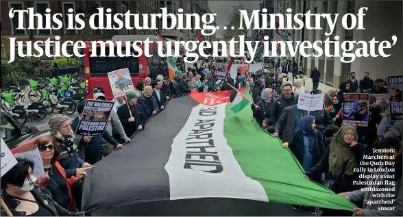  ?? ?? Tension: Marchers at the Quds Day rally in London display a vast Palestinia­n flag emblazoned with the ‘apartheid’ smear