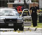  ?? KIN MAN HUI / THE SAN ANTONIO EXPRESS-NEWS ?? Investigat­ors examine bullet casings on Evergreen Street in San Antonio after police and an unknown individual exchanged gunfire after an apparent traffic stop on June 29.