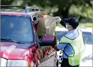  ?? JOHN RAOUX — THE ASSOCIATED PRESS ?? Members of Orange County Fire Rescue and volunteers pass out personal protective equipment to small businesses Wednesday in Orlando, Fla.