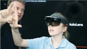  ??  ?? Longwarry Primary School student Talia Gerlach is instructed through using the Microsoft HoloLens by Federation Training teacher Mitch Gazzard.