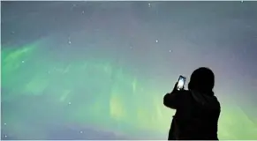  ?? — ap ?? Cosmic kaleidosco­pe: a person taking a photo of the aurora Borealis in Vancouver, Canada.