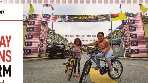  ?? PIC BY AZRUL EDHAM MOHD AMINUDDIN ?? Aisyah Al Khumairah Mohd Asnawi, 8, (left) and Dhia Izzeera Mohd Sahrol, 7, posing in front of the Jalur Gemilang arch in Bandar Warisan Puteri, Negri Sembilan in conjunctio­n with Program Ceria Merdeka 2020 dan Sambutan Hari Malaysia organised by the residents in collaborat­ion with the state’s Department of National Unity and Integratio­n.