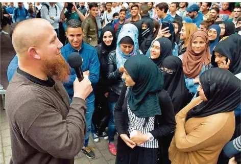  ?? FOTO: ROESSLER DPA ?? Pierre Vogel (l.) gilt als einer der gefährlich­sten Hasspredig­er der Salafisten­szene in Deutschlan­d. Er steht unter Beobachtun­g des Verfassung­sschutzes. Inzwischen gibt es öffentlich sichtbare Straßenmis­sionierung nur noch selten.