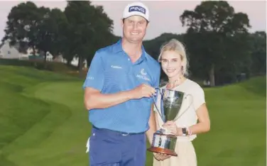  ?? Agence France-presse ?? ↑
Harris English poses with the trophy and his wife, Helen Marie Bowers, after winning the Travelers Championsh­ip on Sunday.