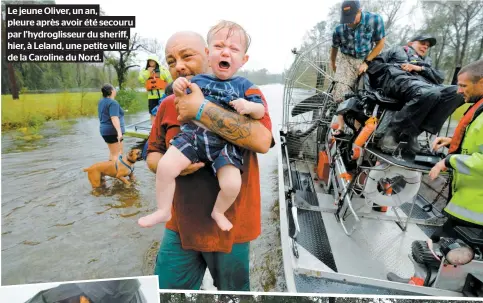  ??  ?? Le jeune Oliver, un an, pleure après avoir été secouru par l’hydrogliss­eur du sheriff, hier, à Leland, une petite ville de la Caroline du Nord.