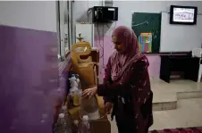  ?? ?? Ines Tehini, who fled her village in southern Lebanon with her family after Hezbollah and Israel began exchanging fire, boils water for tea at a school turned to shelter in Tyre.ANWAR AMRO