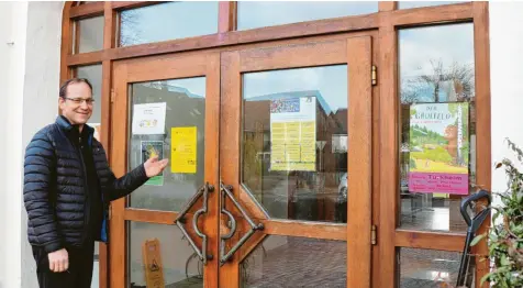  ?? Fotos: Alf Geiger ?? Türkheims Pfarrer Martin Skalitzky vor dem Eingang zum Pfarrheim: Schon die Zahl der Plakate zeige, dass die Auslastung gut sei.