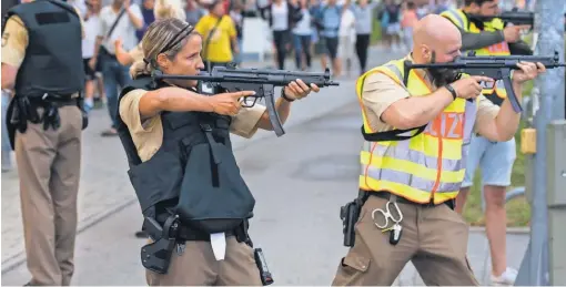  ?? JOERG KOCH, GETTY IMAGES ?? Munich police stand guard as other officers escort people to safety.