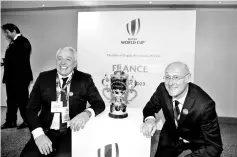  ??  ?? President of the French bid Claude Atcher (L) and French rugby President Bernard Laporte pose with the trophy after France was named to host the 2023 RugbyWorld Cup in London on November 15, 2017. France won the right to stage the 2023 World Cup, it...