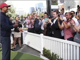  ??  ?? U.S. captain Tiger Woods poses for photos for fans during a media conference in Melbourne, today. DAVID CROSLING/AAP IMAGE VIA AP