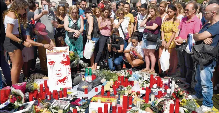  ?? Foto: Pascal Guyot, afp ?? Die Menschen in Barcelona lassen sich nicht unterkrieg­en: Sie kommen auf die Ramblas, legen Blumen und Kerzen nieder.