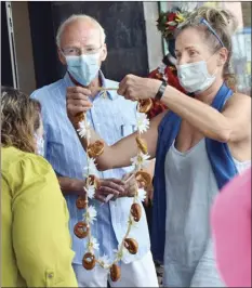  ?? The Maui News / MATTHEW THAYER photos ?? Maui Bread Company owners
Christine and Steve Lange present a pretzel lei to Maui Chamber of Commerce President Pamela Tumpap during Friday morning’s blessing ceremony for the company’s store and bake shop at Dolphin Plaza in Kihei. The German couple with a passion for artisan breads bought the business just months before the pandemic started. They said after a long journey and delays due to worldwide circumstan­ces, they were pleased to have the blessing.