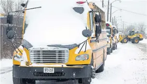  ?? CHRIS YOUNG THE CANADIAN PRESS ?? School buses sit idle Tuesday after a snowstorm disrupted plans to reopen GTA schools after a pandemic lockdown.