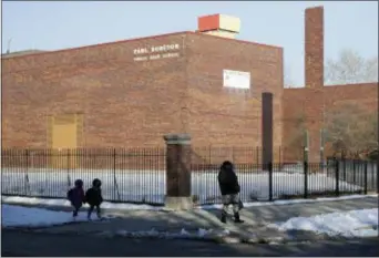  ?? CHARLES REX ARBOGAST — THE ASSOCIATED PRESS ?? In this photo,people walk past Paul Robeson High School in the Englewood neighborho­od of Chicago. Five years after the nation’s largest mass closure of public schools, Chicago is forging ahead with plans to shutter four more in one of the city’s...