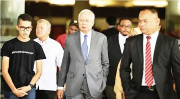  ??  ?? Najib (centre) arrives at Kuala Lumpur Court Complex for the hearing of charges on three counts of money laundering amounting RM27 million of SRC Internatio­nal Sdn Bhd funds. — Bernama photo