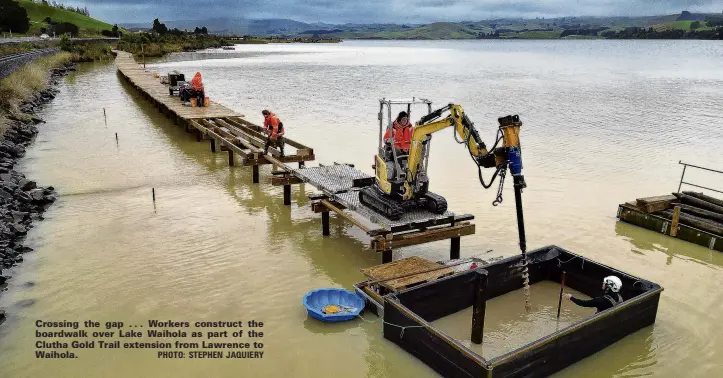  ?? PHOTO: STEPHEN JAQUIERY ?? Crossing the gap . . . Workers construct the boardwalk over Lake Waihola as part of the Clutha Gold Trail extension from Lawrence to Waihola.