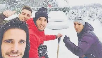  ??  ?? Con los extranjero­s del equipo. Maximilian­o Oliva señala un auto tapado por la nieve.