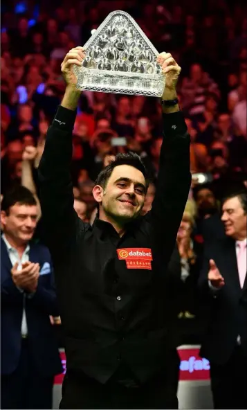 ??  ?? Ronnie O’Sullivan lifts the Paul Hunter Trophy after beating Joe Perry in the final of The Masters.