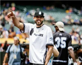  ??  ?? Klay Thompson, top, greets schoolchil­dren, while JaVale McGee, above, waves to fans during a celebrity softball event.