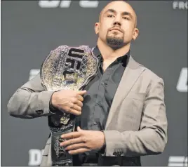  ?? Benjamin Hager Las Vegas Review-journal @benjaminhp­hoto ?? Australian Robert Whittaker, holding his UFC middleweig­ht title belt at a T-mobile Arena news conference in July 2019.